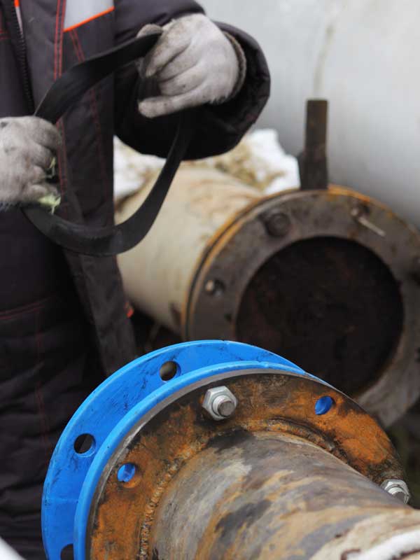 trenchless vs pipe replacement, is CIPP pipe lining worth it? - Workers install a cured-in-place pipe (CIPP) renewal systems. One worker prepares a cushion gum, another one holds a pipe fitting part